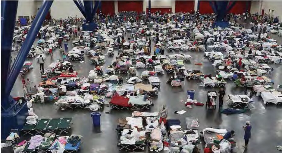 Large room filled with people on cots